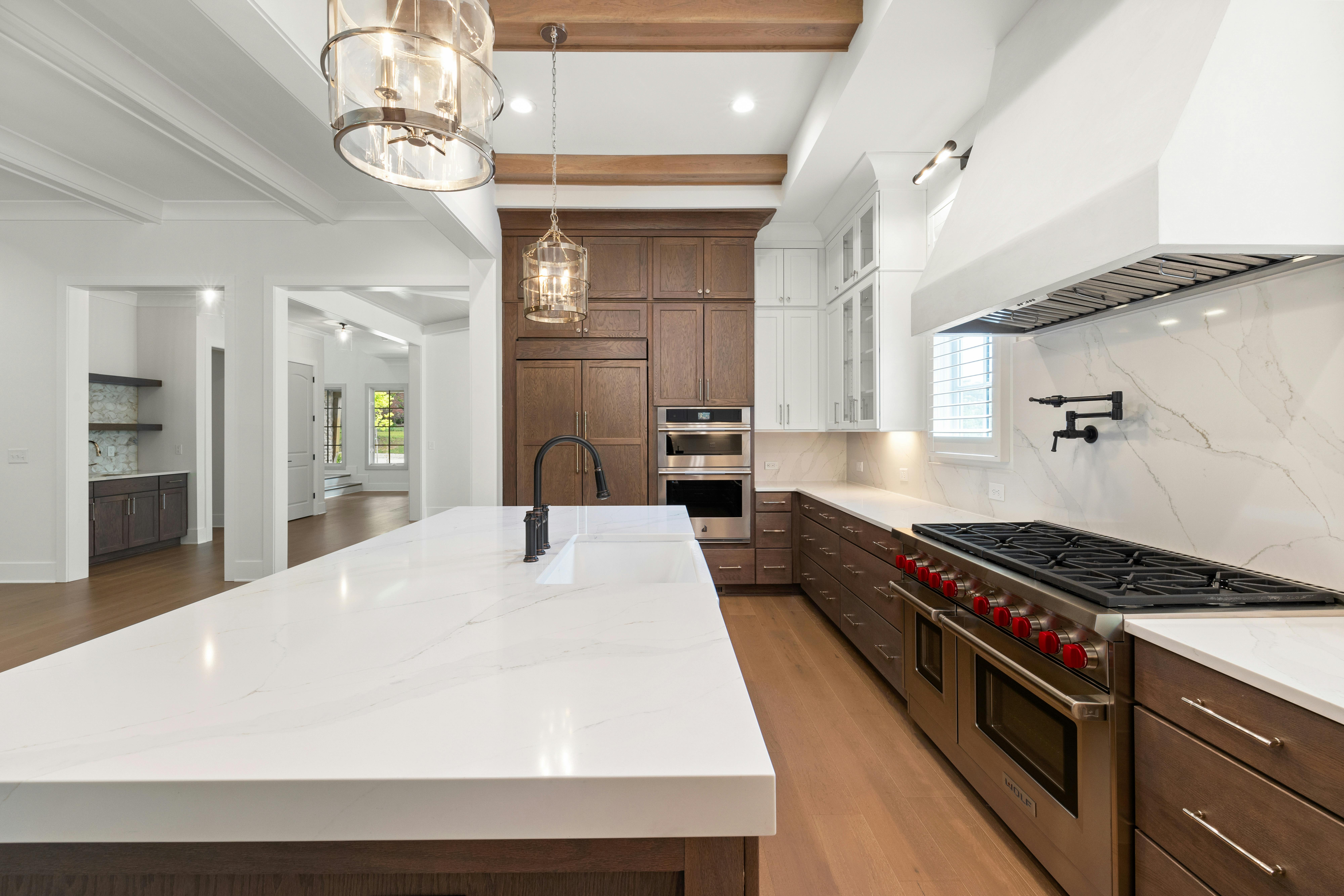 Elegant modern kitchen featuring marble countertops, stainless steel appliances, and hardwood floors.